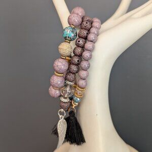 3 mauve beaded stretch layering bracelets with gold, silver and tassel accents